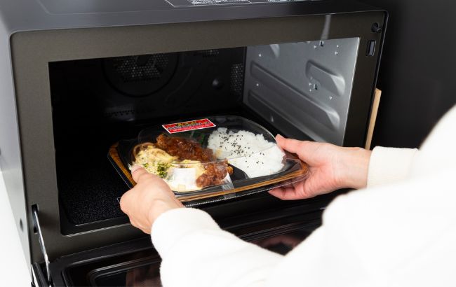 レンジでスーパーのお弁当をチンしている画像